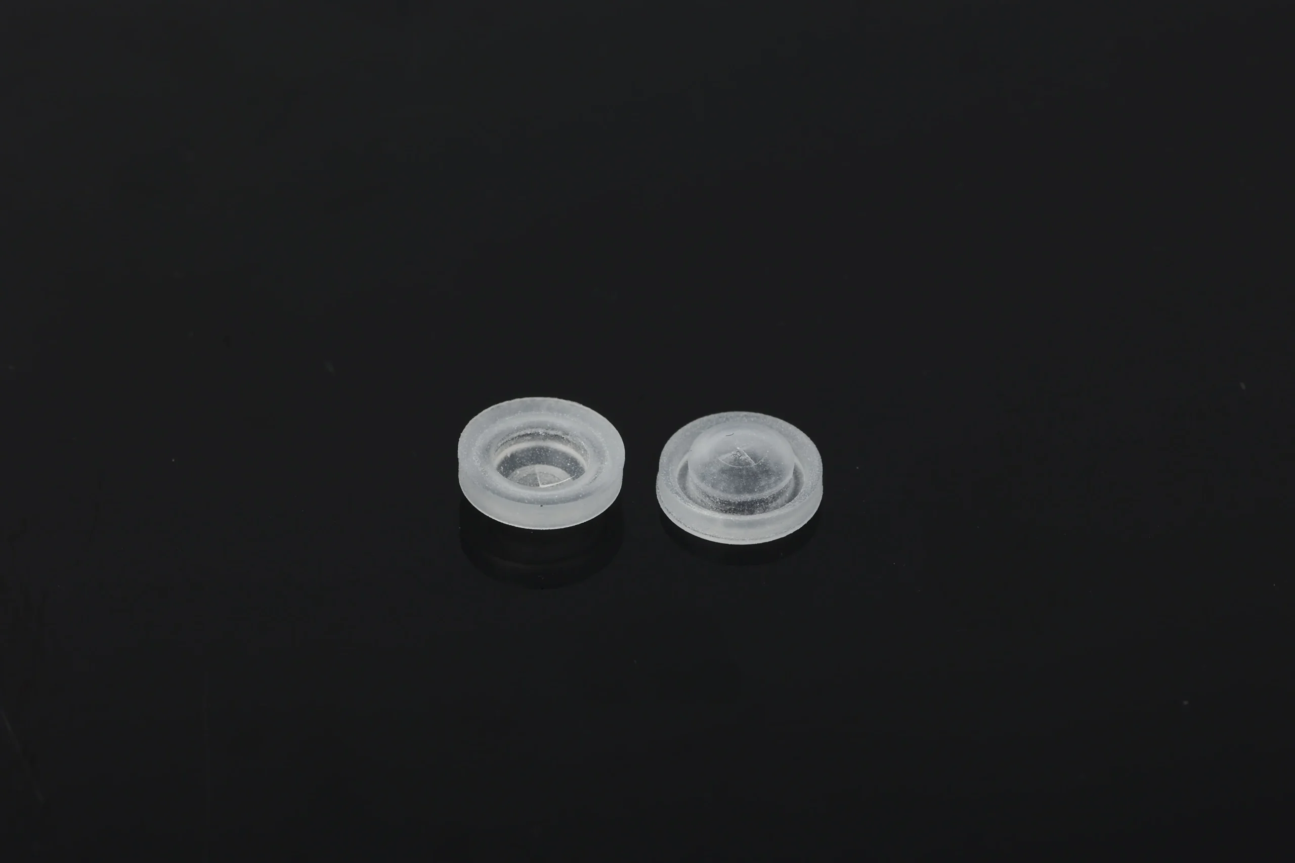 "Silicone valve for ketchup bottles with flip-top cap components before automated assembly"