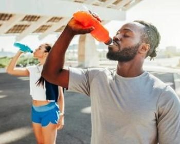 sporty-runners-couple-drinking-energy alt="Close-up of flip top plastic caps on water bottles"